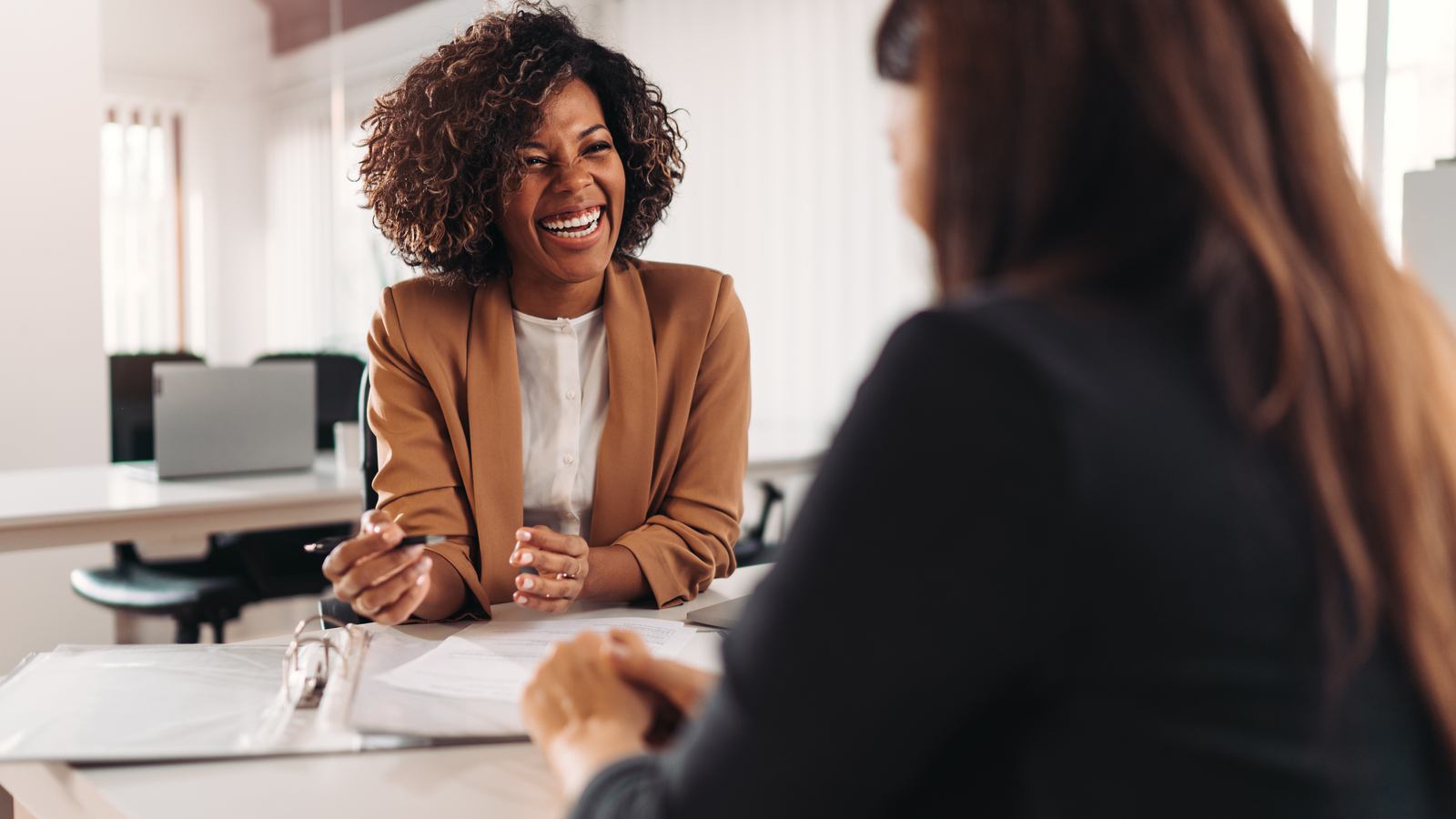 Image showing a client meeting with two women. Maintaining client relationships is essential for businesses - eSign Genie can help.